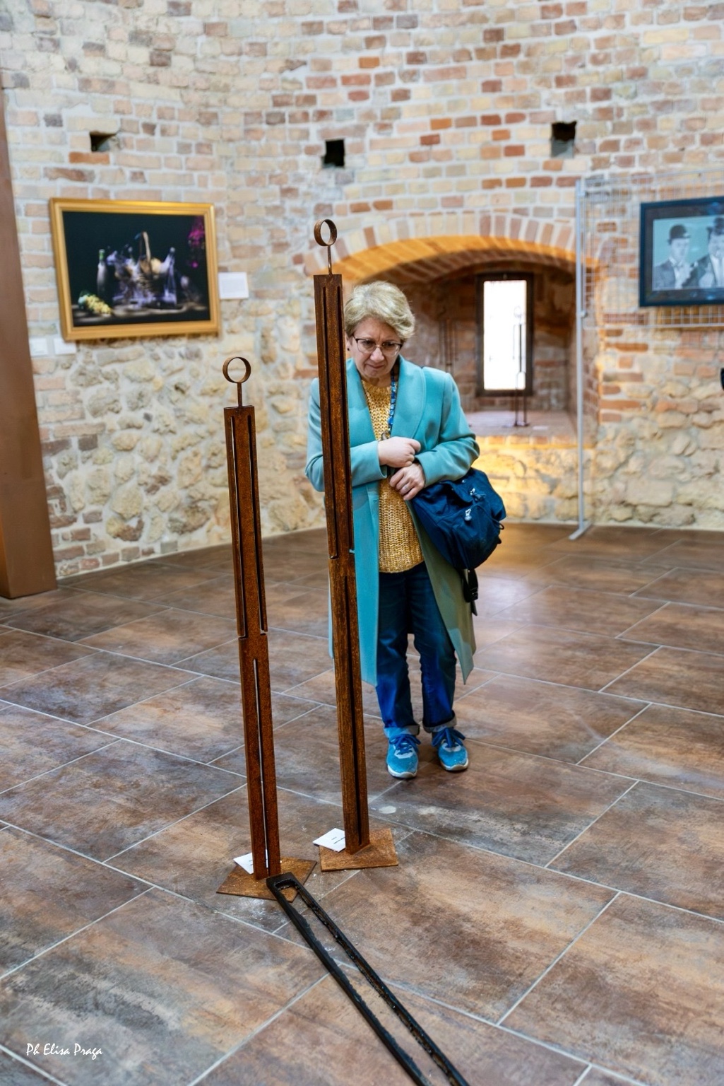 Una visitatrice osserva due figure slanciate in ferro a Moncalvo Expo