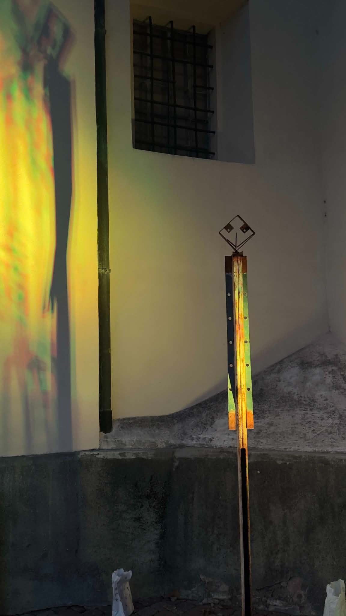 Figura slanciata in ferro e la sua ombra sulla parete