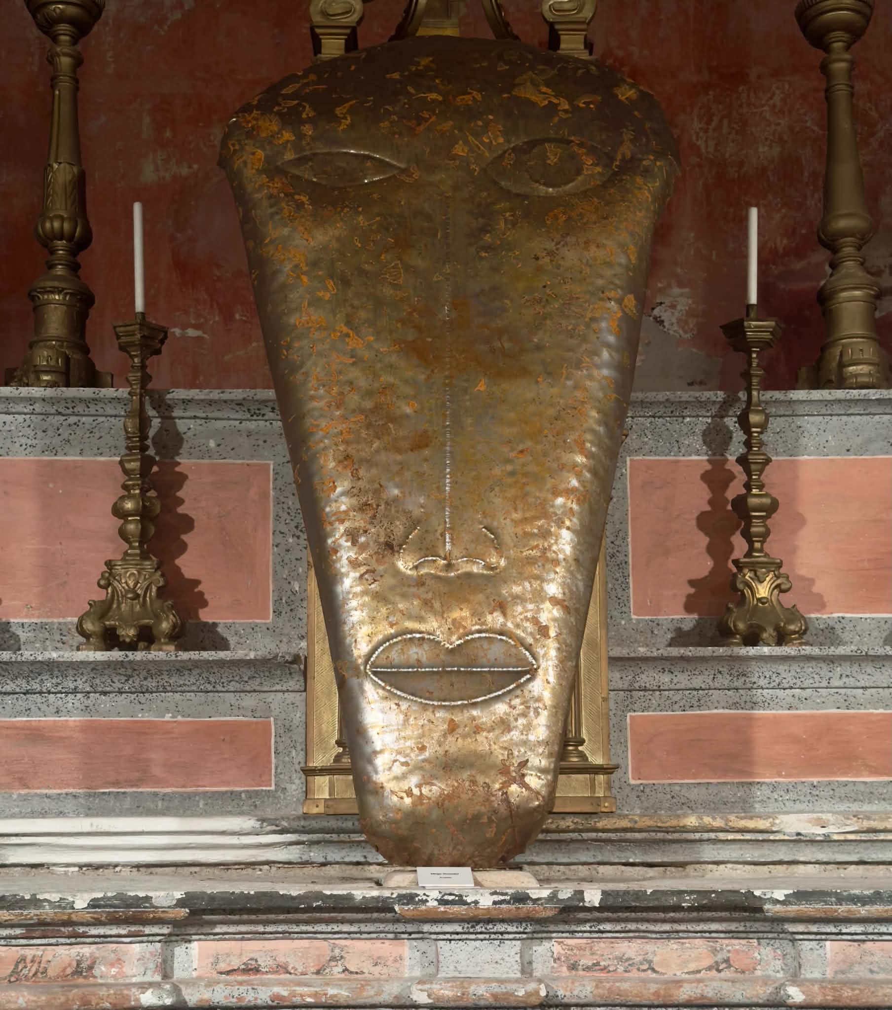 Grande volto in ferro con patina davanti all’altare